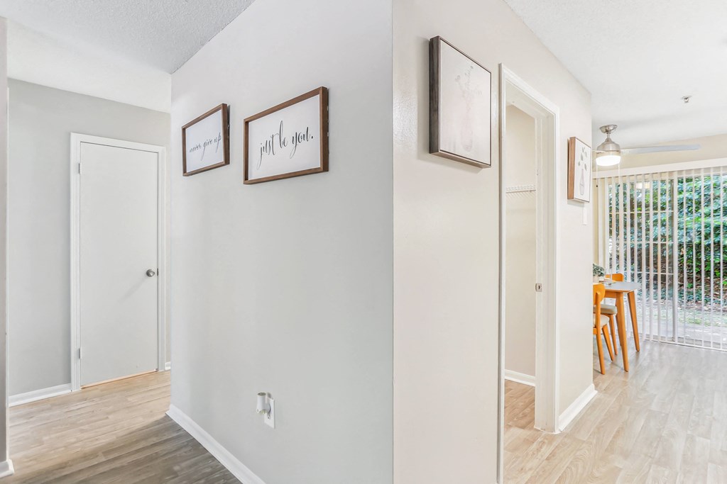 a living room and dining room with white walls and hardwood floors