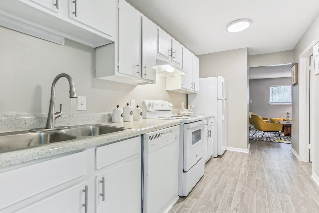 a classic unit kitchen with white cabinets and white appliances