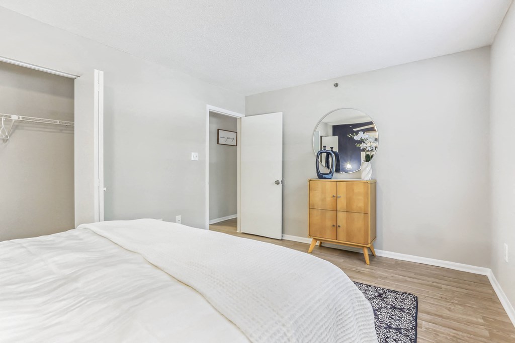 a bedroom with a large bed and a dresser with a mirror