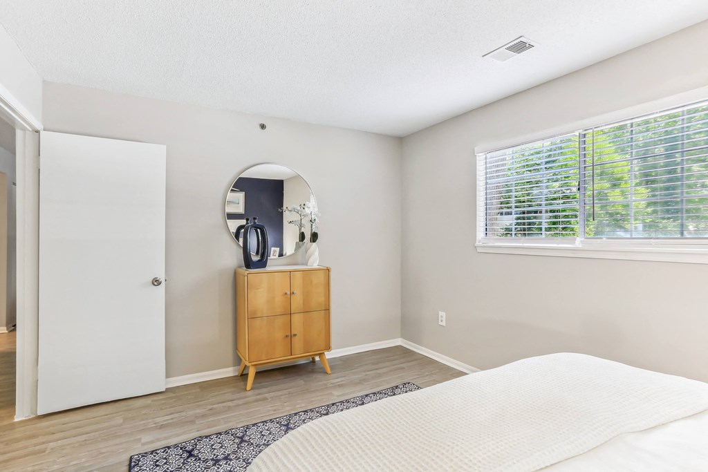 a bedroom with a bed and a dresser with a mirror on top of it