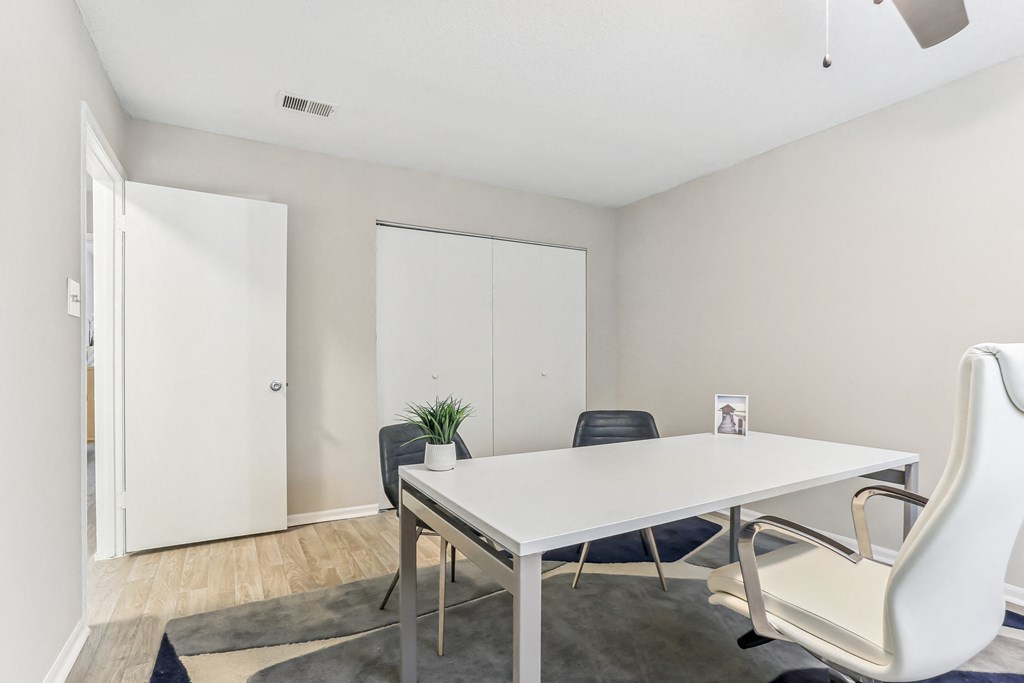 a meeting room with a white table and black chairs