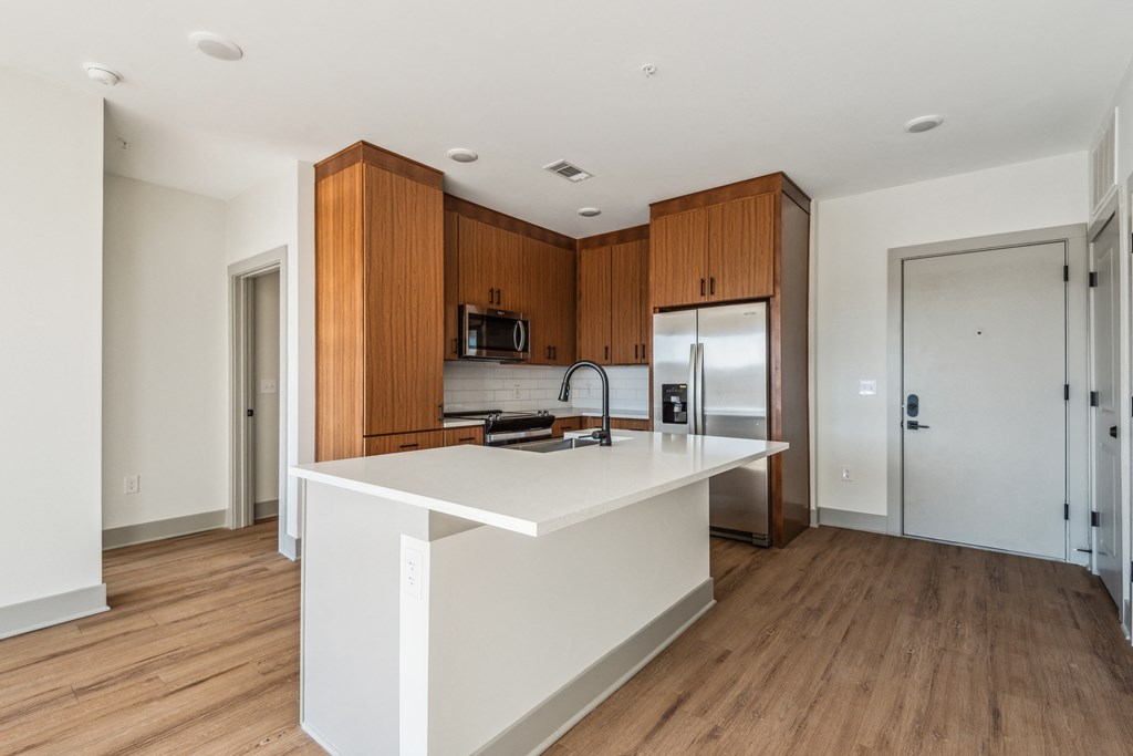 a kitchen with a large white island and wooden cabinets