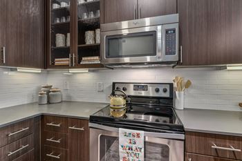 A kitchen with a stove top oven and a microwave above it.
