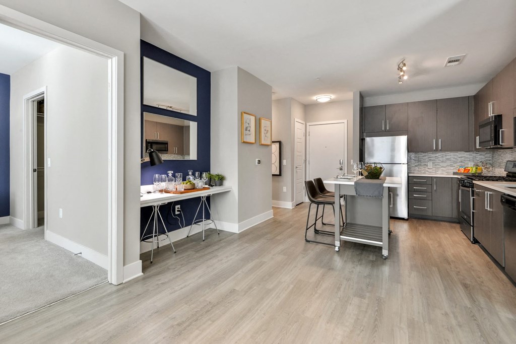 a living room with a kitchen and a table with chairs