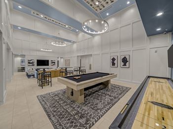 A room with a pool table and a foosball table.