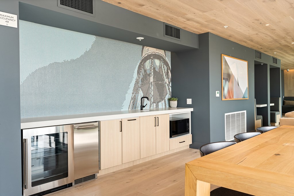 A modern kitchen with a wooden table and stainless steel appliances.