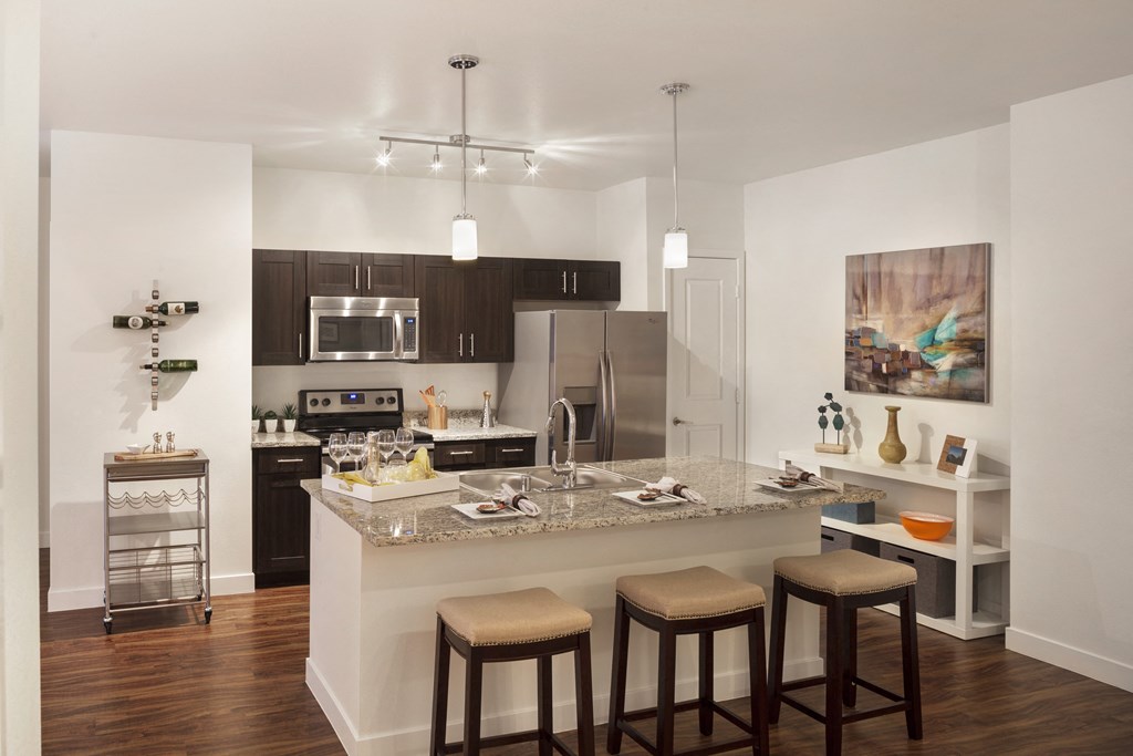 a kitchen with a marble counter top and stools