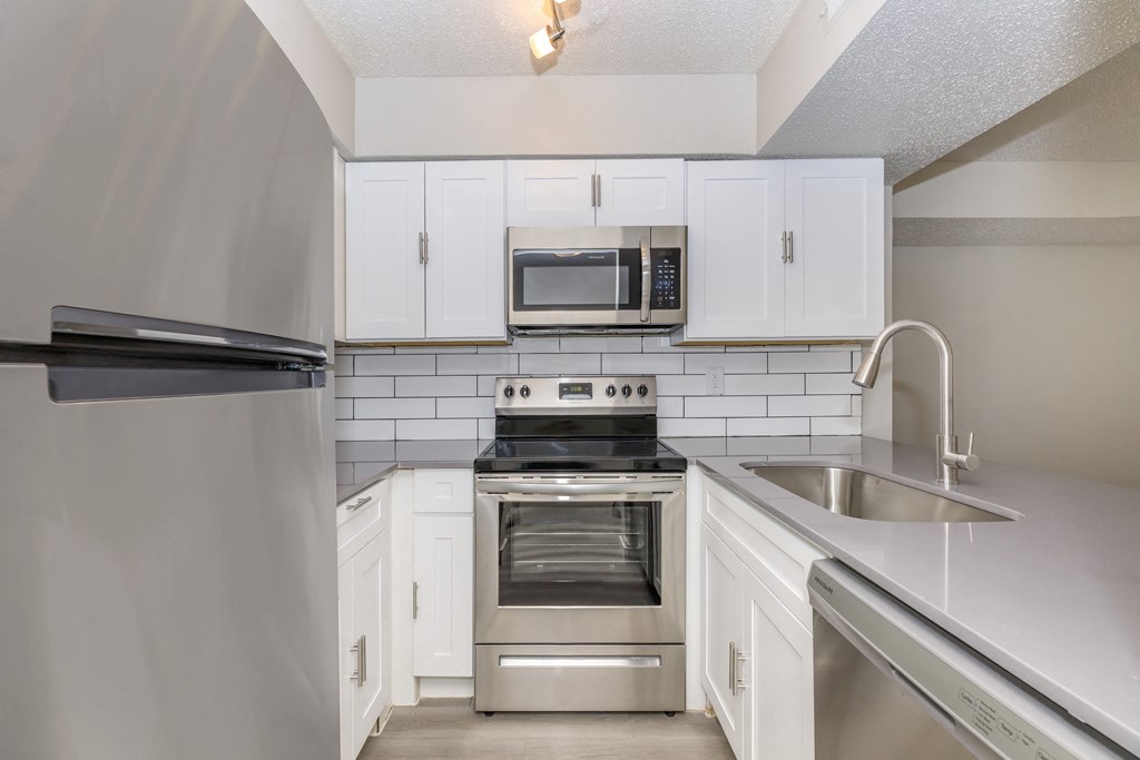 a kitchen with white cabinets and stainless steel appliances