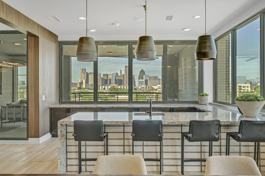 A modern kitchen with a marble countertop and a view of the city.