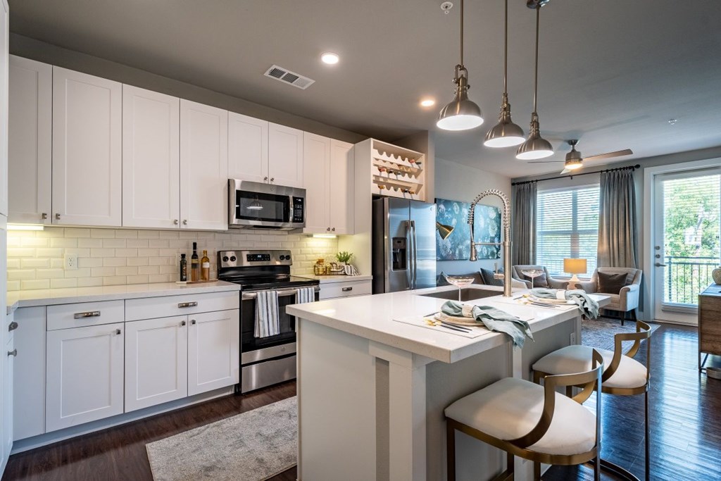 A modern kitchen with white cabinets and a large island.
