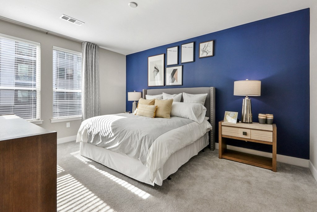 the residence on lamar apartment bedroom with blue wall and white bed