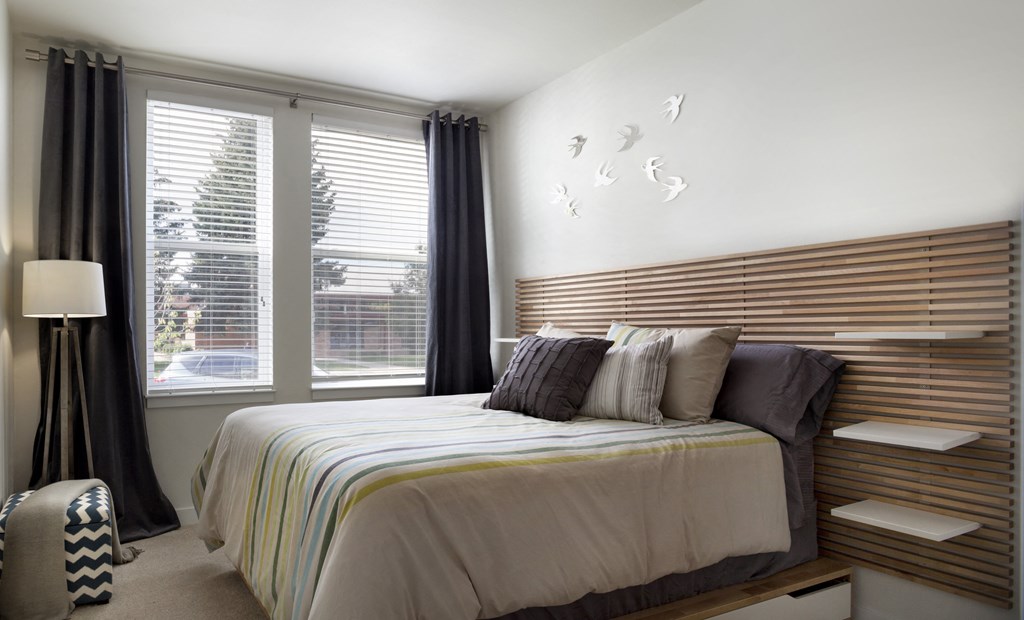 a bedroom with a bed and two windows