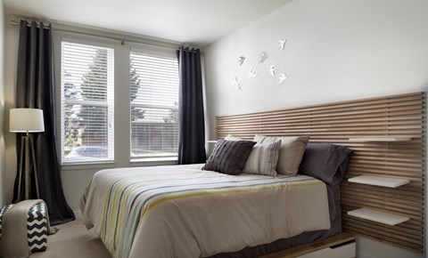 a bedroom with a bed and two windows