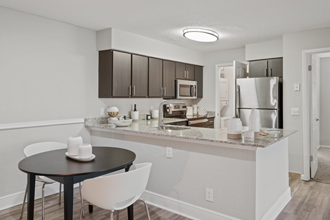 a kitchen and dining area with a table and chairs and a refrigerator