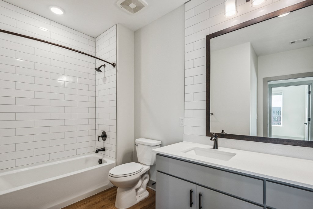 a bathroom with white tiles and a sink and a toilet