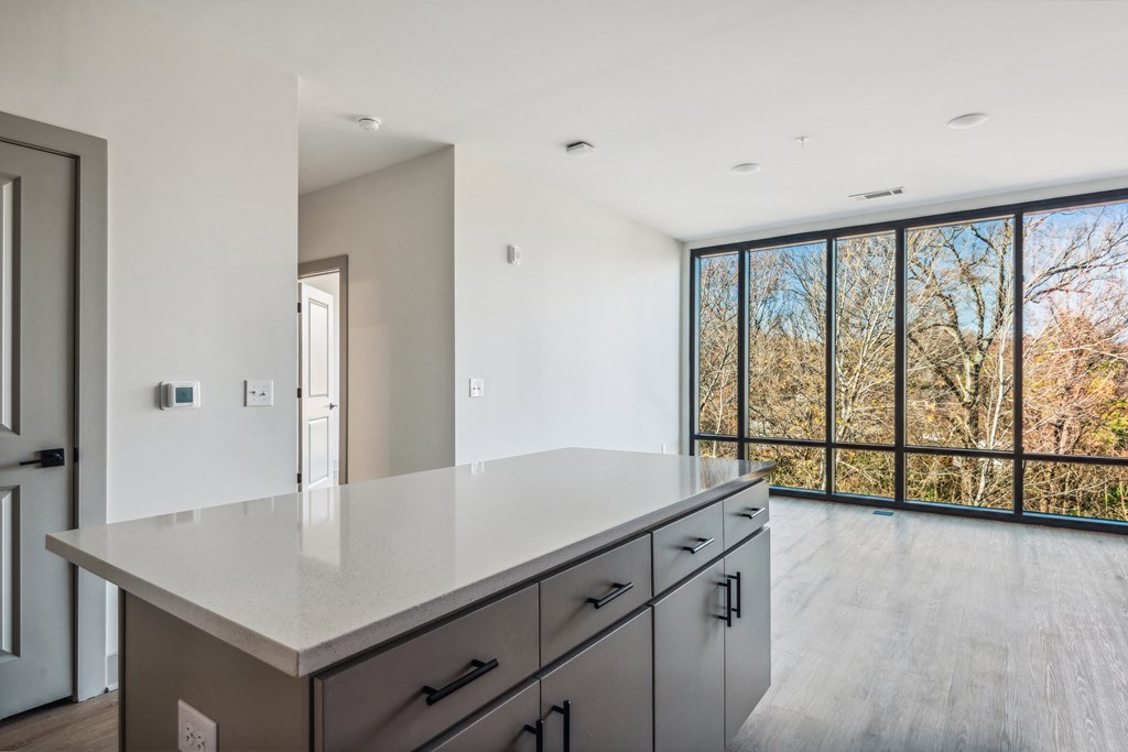 a large white kitchen with a large window and a white counter top