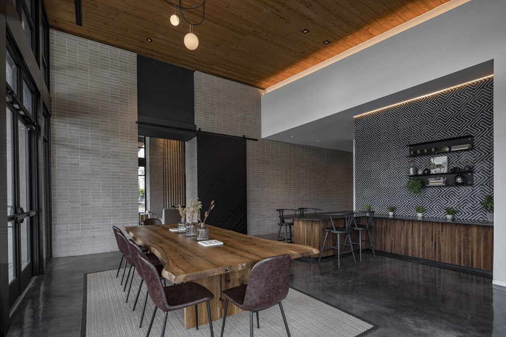 a large wooden table with chairs in a room with brick walls and a wooden ceiling