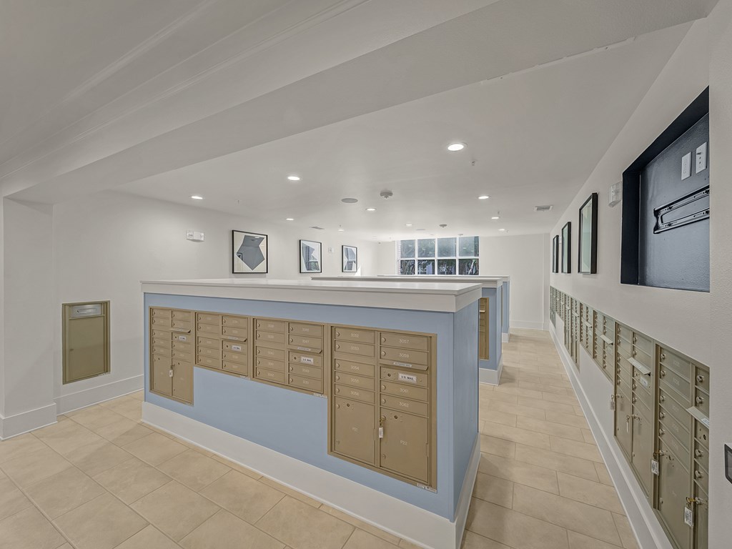 A long hallway with a blue counter and mailboxes on the wall.