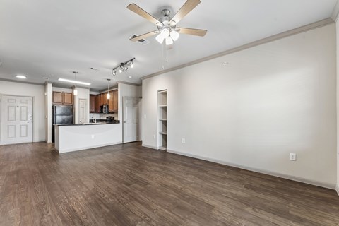 A spacious room with a ceiling fan and wooden flooring.