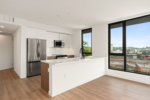A modern kitchen with a stainless steel refrigerator and a microwave oven.
