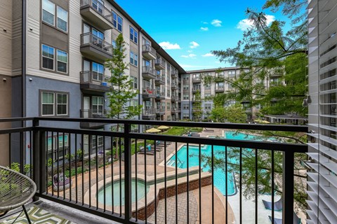 A balcony with a pool and a chair.