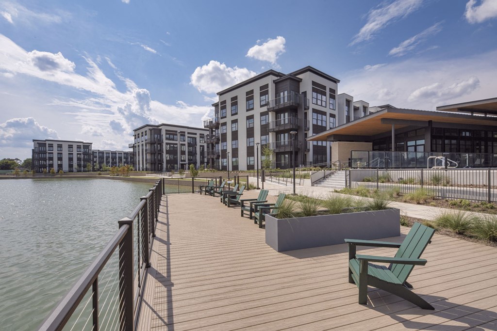 a boardwalk overlooking a lake with a building in the background