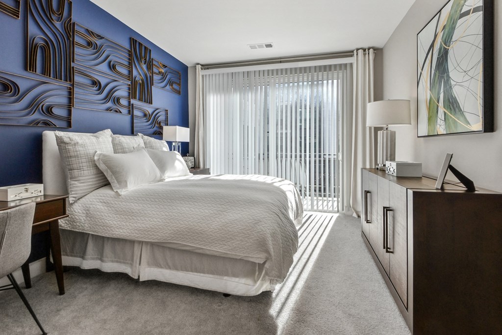 a bedroom with a bed and a dresser and a window