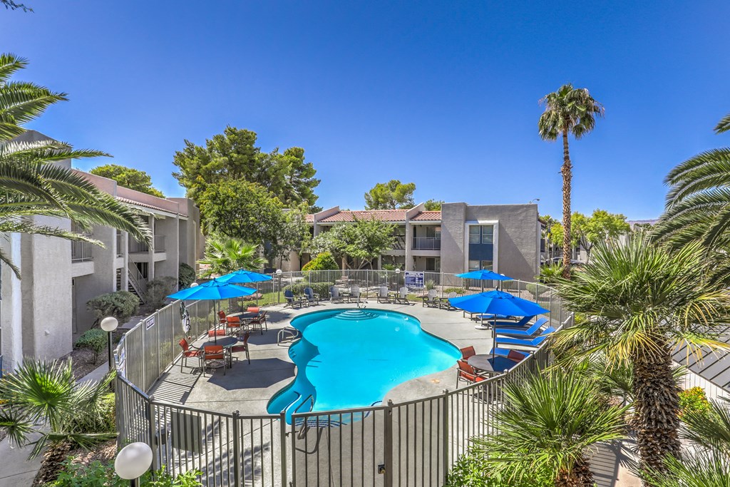 a swimming pool with umbrellas and chairs around it at a resort style community