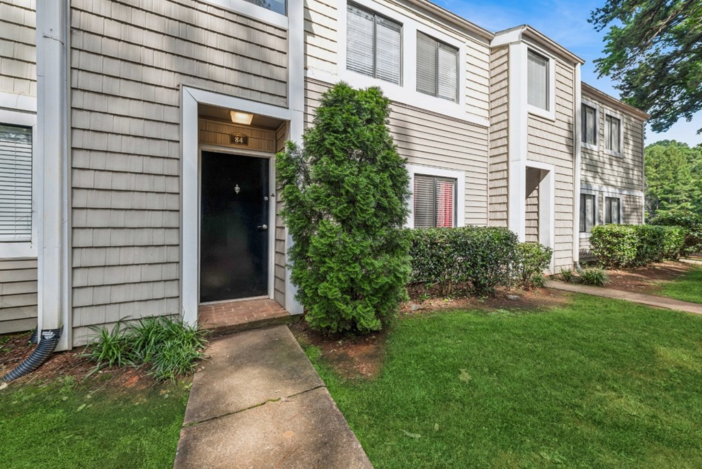 A building with a grey facade and a red door.