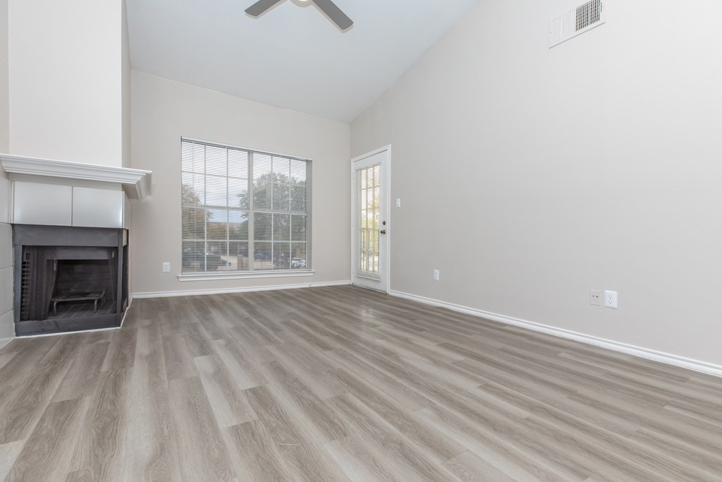 a living room with a fireplace and a large window