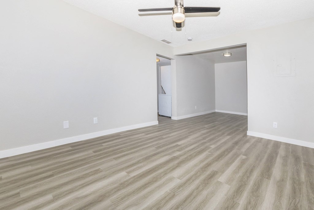 the living room and dining room of an empty apartment