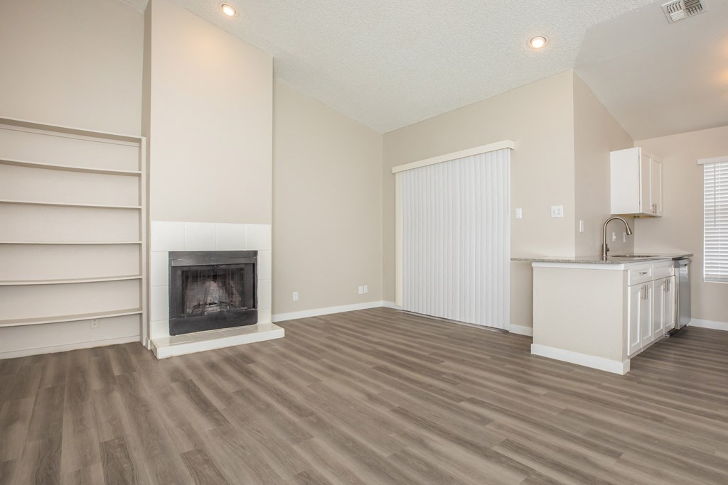 a living room with a fireplace and a kitchen