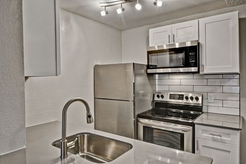 a kitchen with stainless steel appliances and white cabinets
