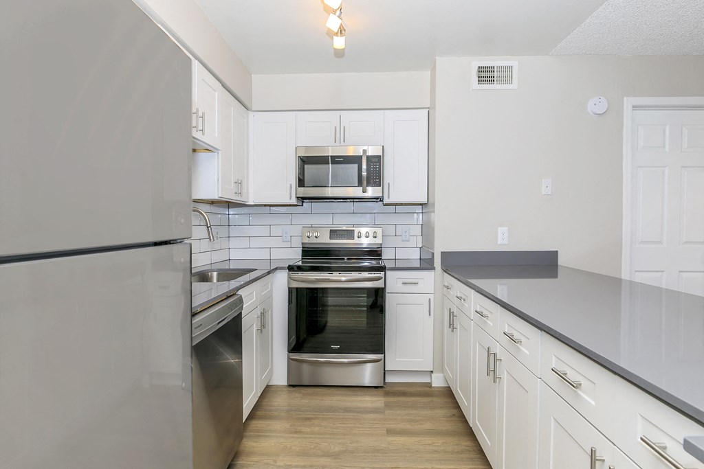 a kitchen with white cabinets and stainless steel appliances