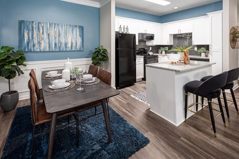 A modern kitchen with a dining table set for two.