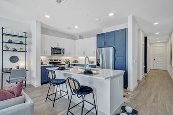 A kitchen with a white island and blue cabinets.
