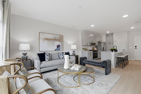 A modern living room with a grey sofa, a coffee table, and a painting on the wall.