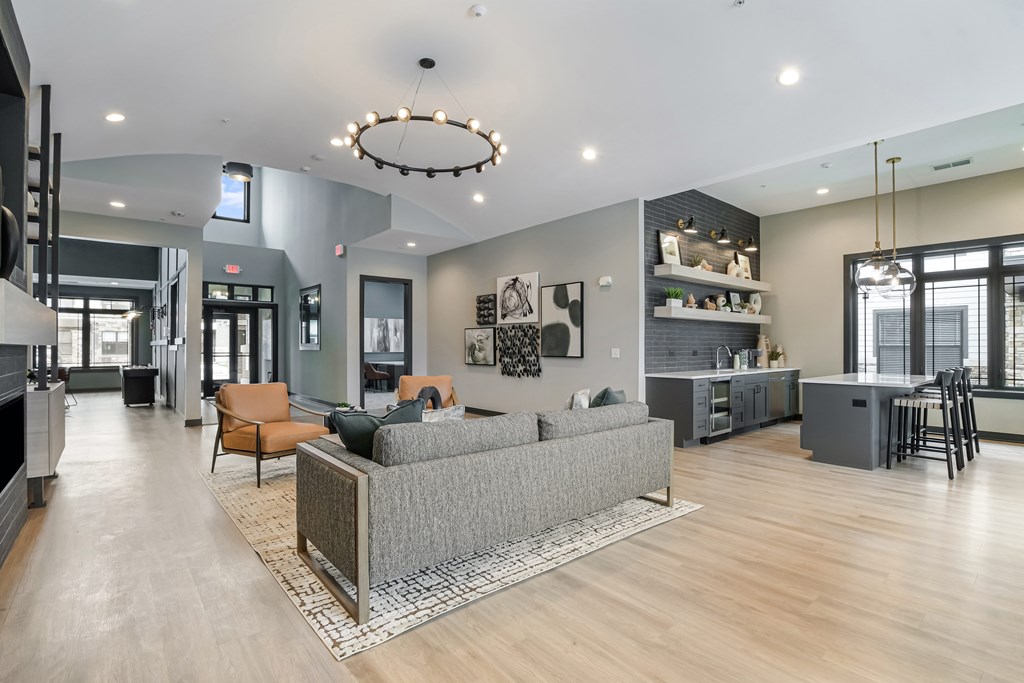 A modern living room with a grey sofa and a wooden floor.