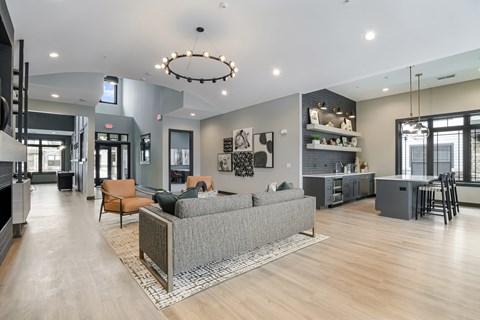 A modern living room with a grey sofa and a wooden floor.