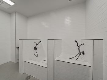 Two white bathrooms with white tiles and white fixtures.