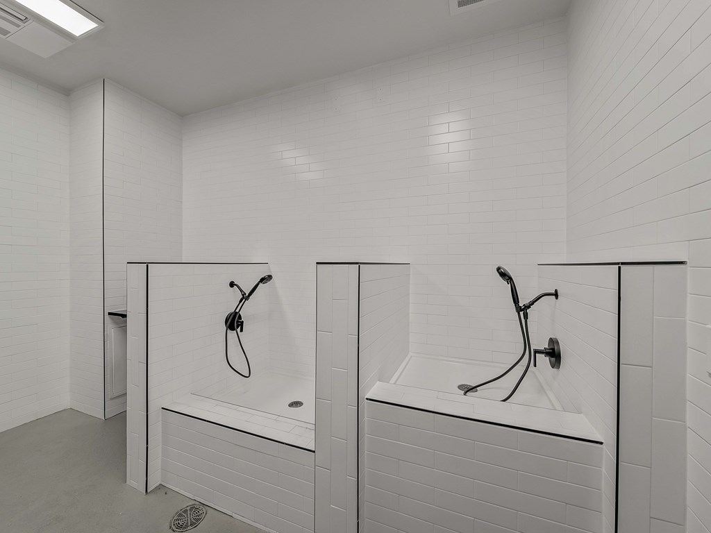 A white bathroom with two sinks and a shower.