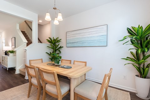 A dining room with a wooden table and chairs.