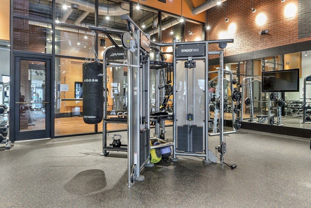 a gym with weights and cardio equipment in a building with glass doors