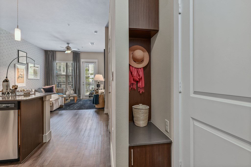 A kitchen with a washing machine and a hat on a hook.
