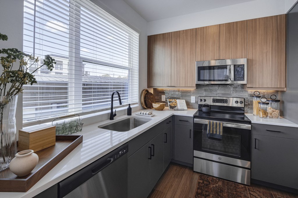 a kitchen with gray cabinets and white countertops