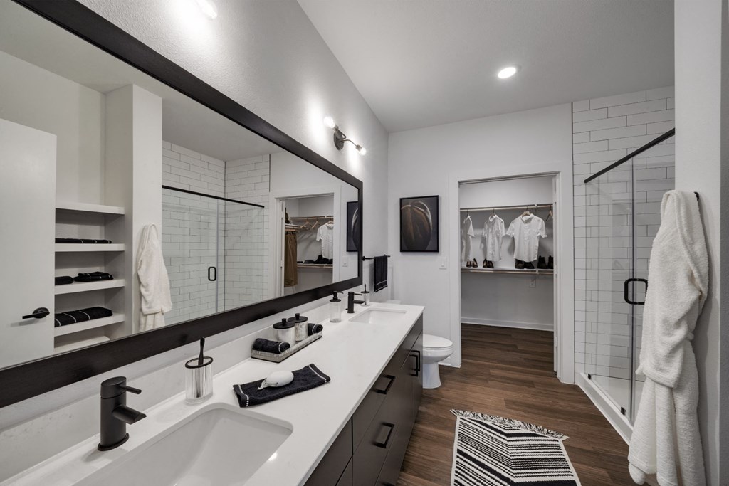 a bathroom with two sinks and a walk in shower in a 555 waverly unit