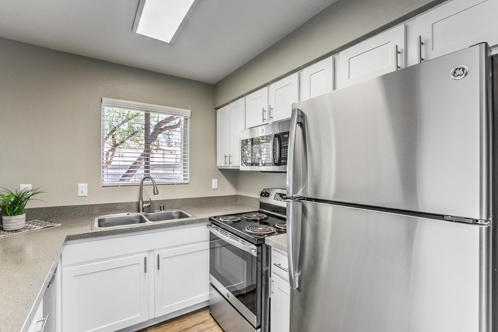 a kitchen with stainless steel appliances and white cabinets