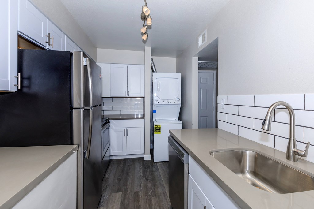 a kitchen with white cabinets and stainless steel appliances and a sink