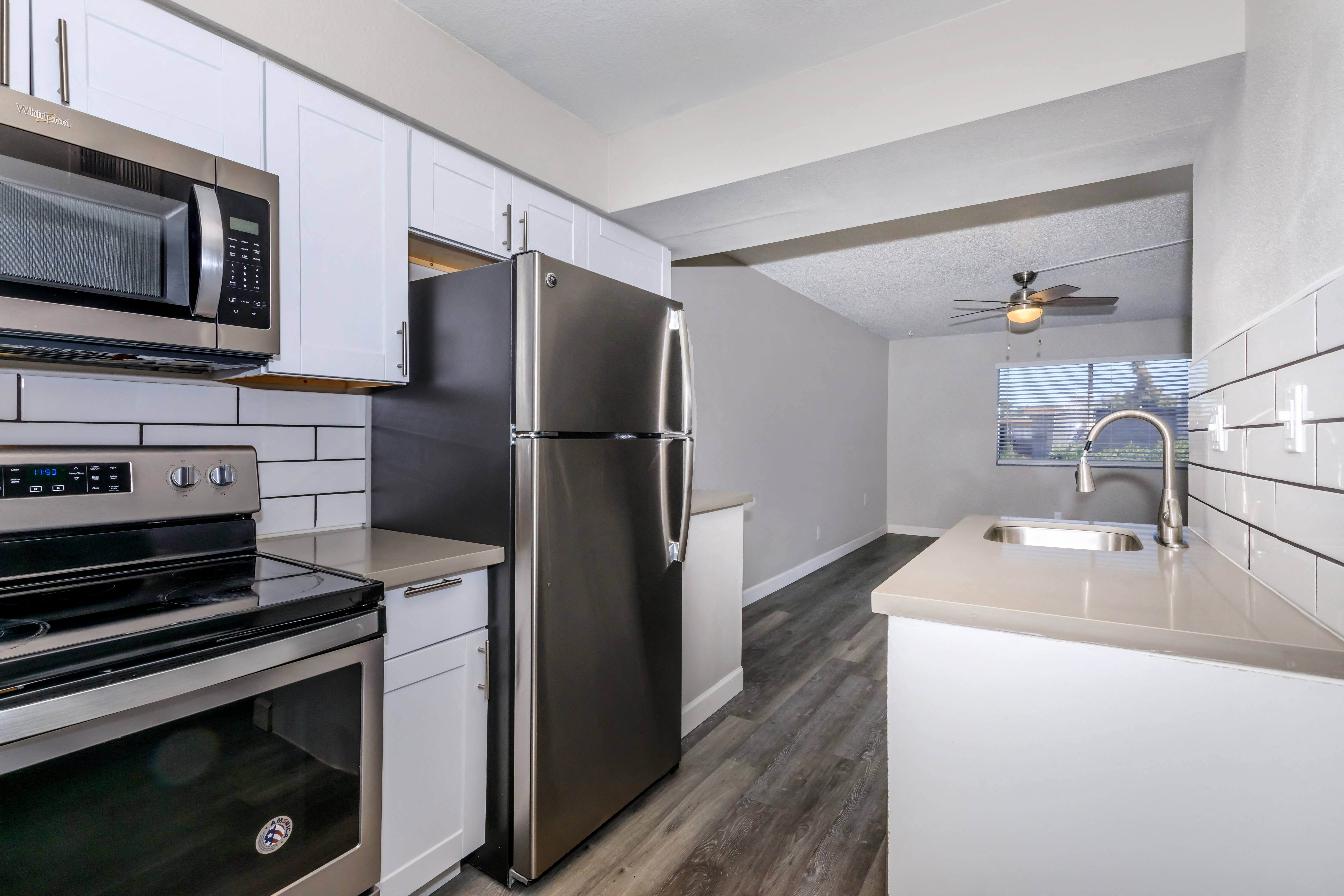 a kitchen with stainless steel appliances and white cabinets