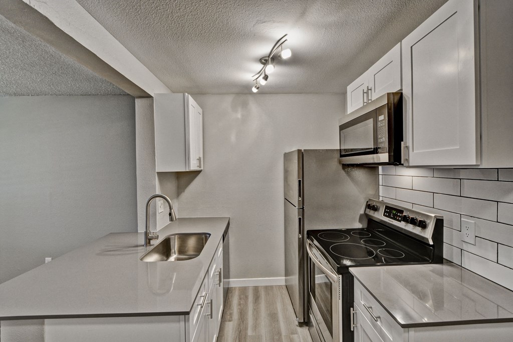 a kitchen with white cabinets and stainless steel appliances